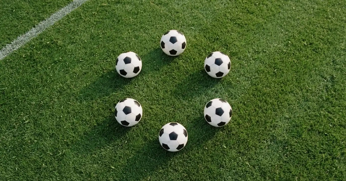 Sechs Fußbälle in einem Kreis auf einem gepflegten Rasen, von oben aufgenommen, gleichmäßiges Tageslicht.