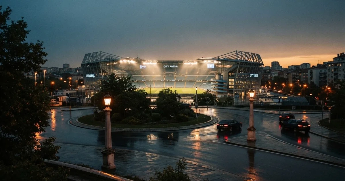 Ein Fußballstadion in der Dämmerung aus der Ferne, die Flutlichter gerade eingeschaltet, davor ein Kreisverkehr mit Laternen.